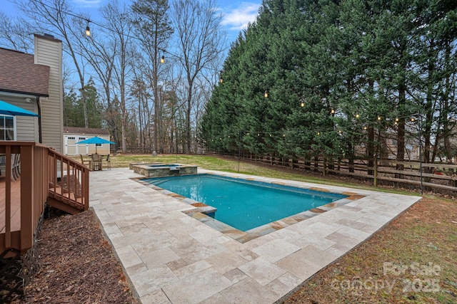 view of swimming pool with a storage shed, a patio area, and an in ground hot tub