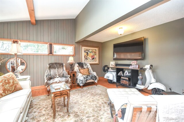 living room with beamed ceiling, hardwood / wood-style floors, and wooden walls