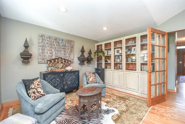 living area featuring light hardwood / wood-style flooring and lofted ceiling