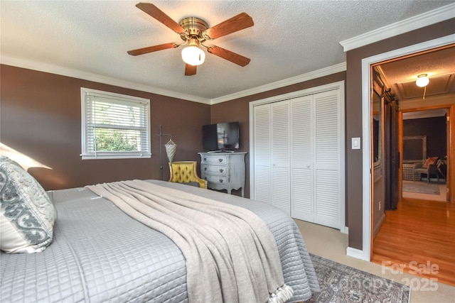 bedroom featuring hardwood / wood-style floors, crown molding, ceiling fan, a textured ceiling, and a closet