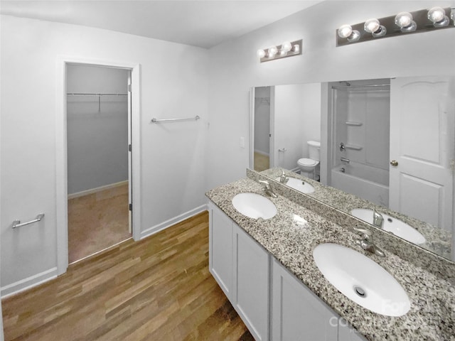 full bathroom featuring hardwood / wood-style flooring, shower / bathing tub combination, toilet, and vanity