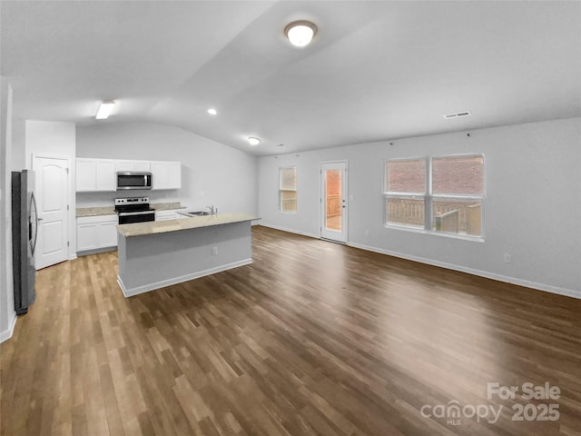 kitchen featuring appliances with stainless steel finishes, sink, white cabinets, a center island with sink, and lofted ceiling