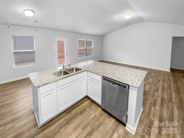 kitchen featuring dishwasher, lofted ceiling, white cabinetry, sink, and light stone counters