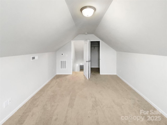 bonus room with light colored carpet and lofted ceiling