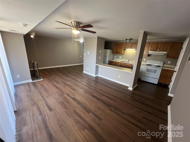 unfurnished living room with ceiling fan, sink, and dark wood-type flooring