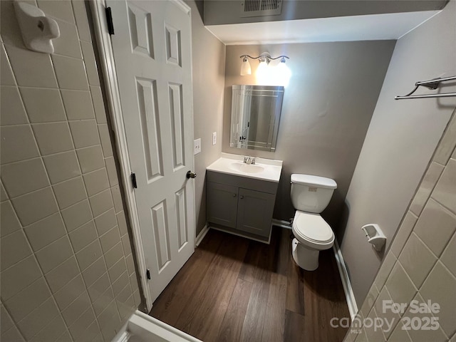 bathroom with vanity, hardwood / wood-style flooring, and toilet