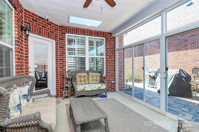 sunroom / solarium with ceiling fan and a skylight