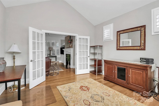 office featuring vaulted ceiling, french doors, and light wood-type flooring