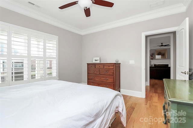 bedroom featuring baseboards, visible vents, ceiling fan, crown molding, and light wood-style floors