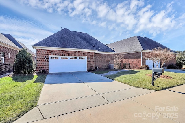 view of front of property featuring a garage, a front yard, and central AC unit