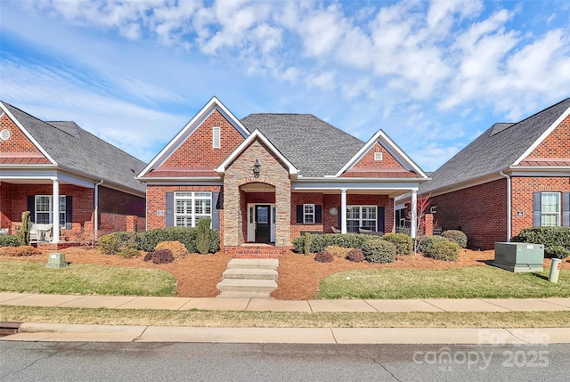 view of front of house featuring a shingled roof, brick siding, and a front lawn