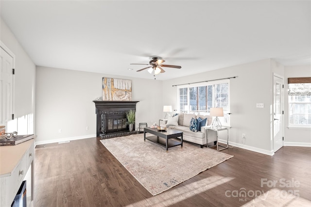 living room with ceiling fan and dark wood-type flooring