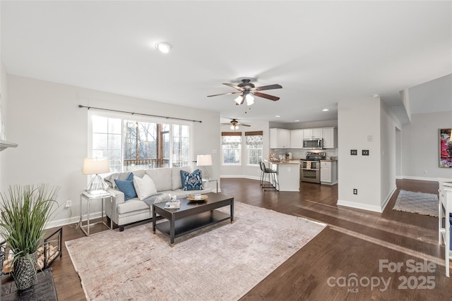 living room with dark hardwood / wood-style flooring and ceiling fan