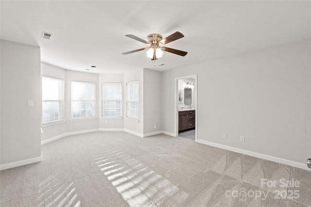 spare room with ceiling fan and light carpet