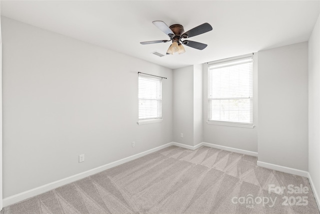 empty room with ceiling fan and light carpet