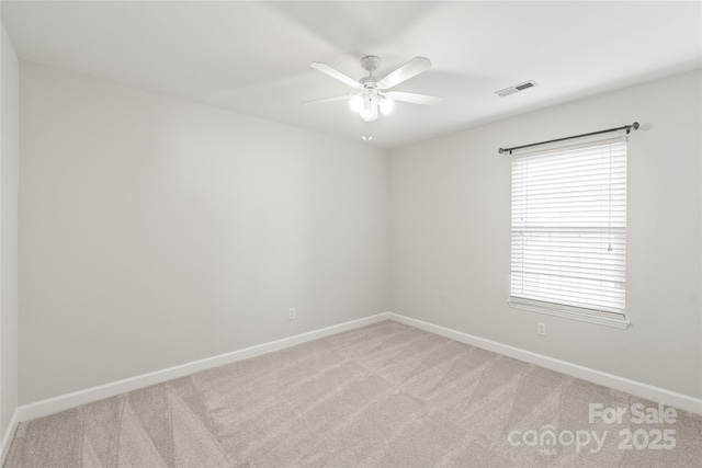 empty room featuring ceiling fan and light colored carpet