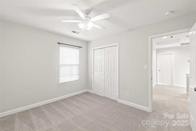 unfurnished bedroom with ceiling fan, a closet, and light carpet