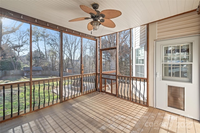 unfurnished sunroom with ceiling fan