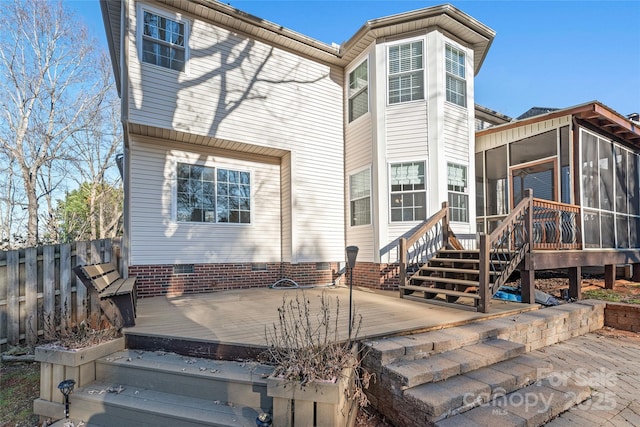 back of property with a sunroom and a wooden deck