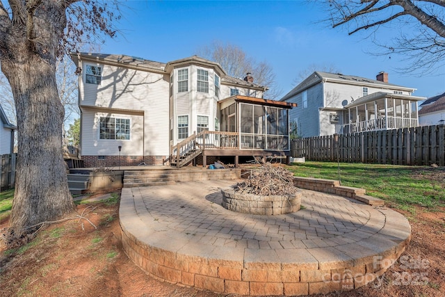 rear view of house featuring a lawn, a sunroom, a fire pit, a deck, and a patio