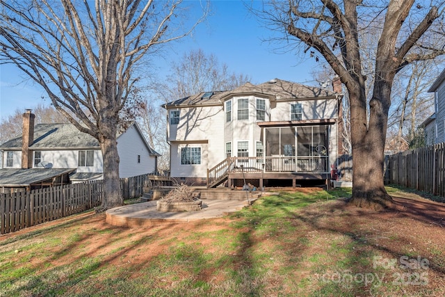 back of property with a sunroom, a yard, and a wooden deck