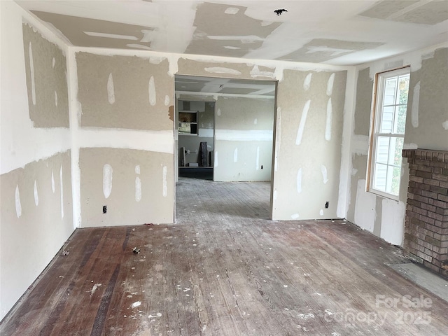 spare room featuring a brick fireplace