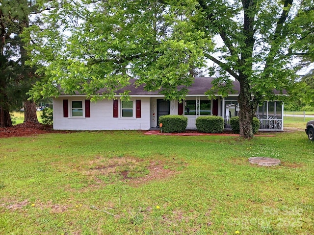 single story home with a sunroom and a front lawn