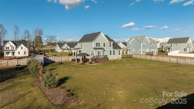 rear view of house with a wooden deck and a lawn