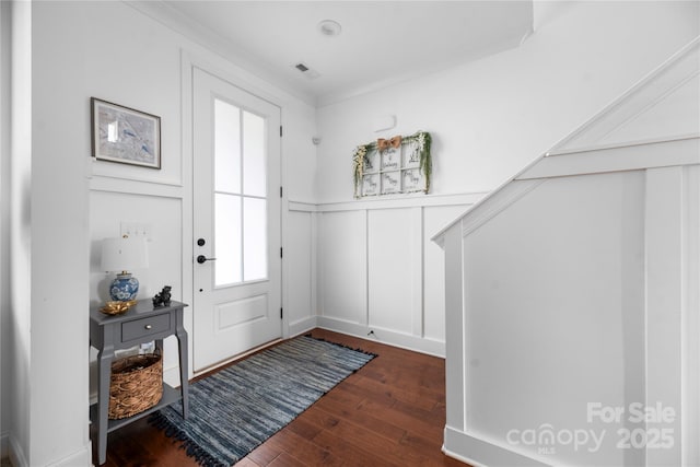 entrance foyer with ornamental molding and dark wood-type flooring