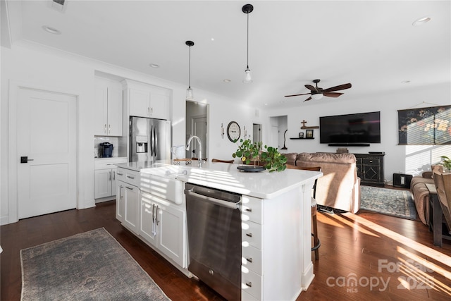 kitchen with white cabinetry, ceiling fan, hanging light fixtures, stainless steel appliances, and an island with sink