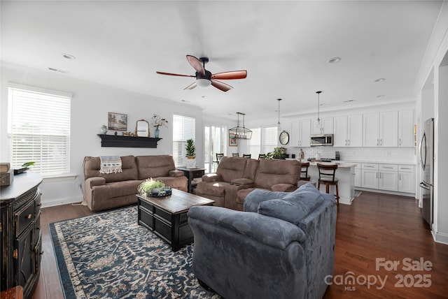 living room featuring dark wood-type flooring, ceiling fan, and crown molding