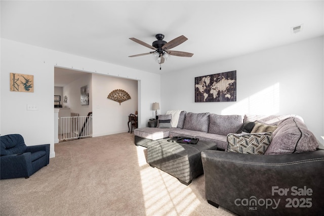 carpeted living room with ceiling fan