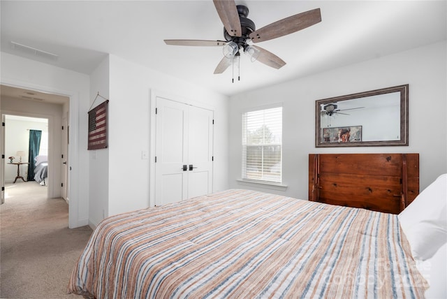 bedroom featuring ceiling fan, light carpet, and a closet