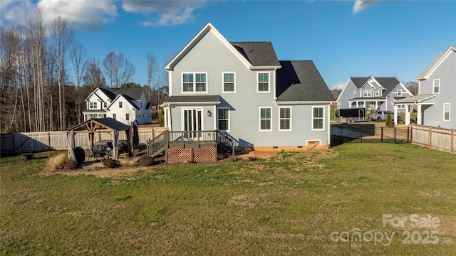 back of property with a gazebo, a wooden deck, and a lawn