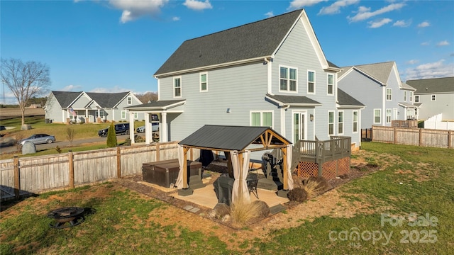 rear view of house with a gazebo, a yard, a hot tub, and a deck