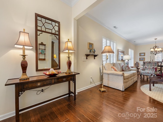 living room with crown molding, hardwood / wood-style floors, and an inviting chandelier