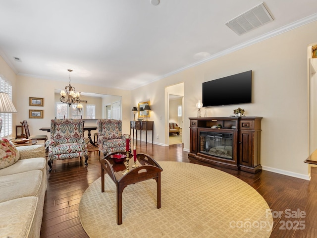 living room featuring ornamental molding, dark hardwood / wood-style flooring, and a notable chandelier