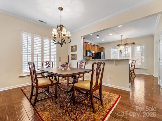 dining space featuring crown molding, dark wood-type flooring, and a chandelier