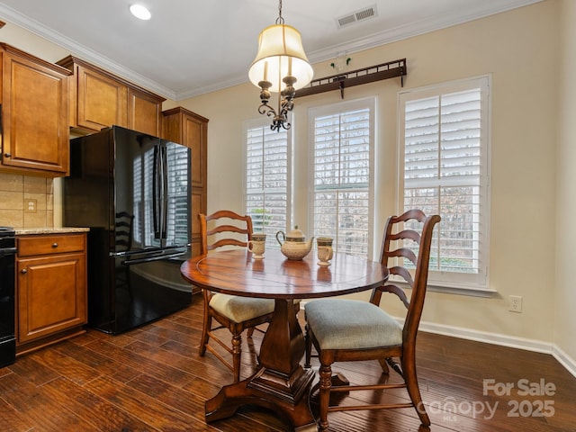 dining space featuring crown molding and dark wood-type flooring