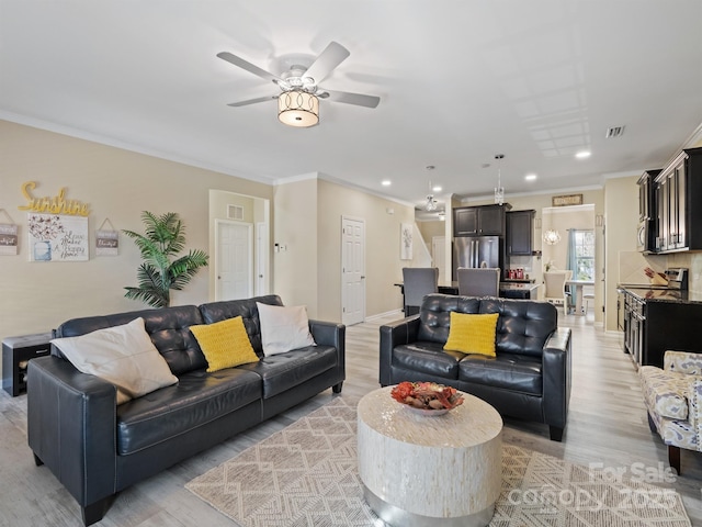 living room featuring ceiling fan, light hardwood / wood-style floors, and ornamental molding