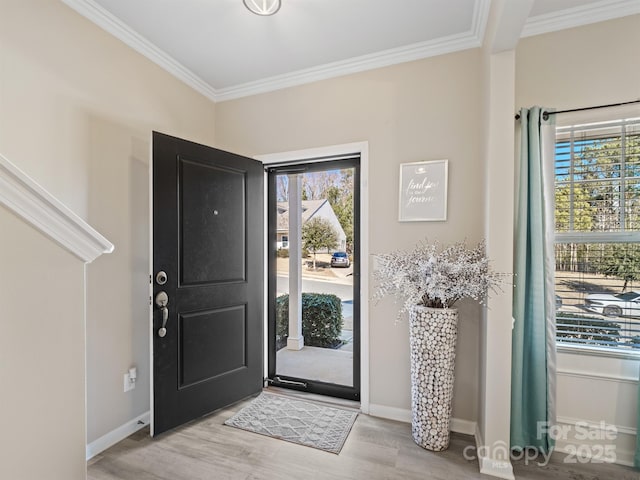 entrance foyer featuring light wood-type flooring, crown molding, and baseboards