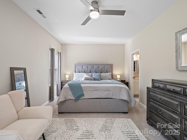 carpeted bedroom featuring ensuite bath, baseboards, visible vents, and ceiling fan