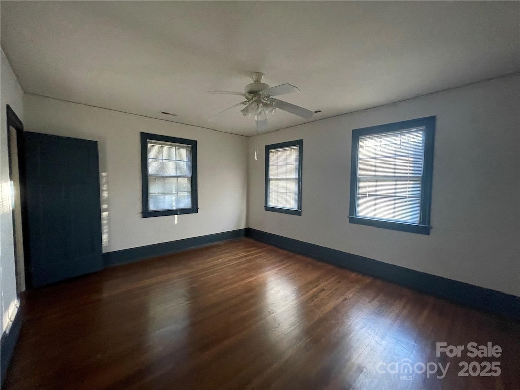 empty room featuring ceiling fan and dark hardwood / wood-style floors