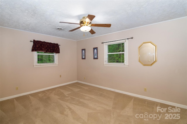 empty room featuring light carpet, ceiling fan, baseboards, and a textured ceiling