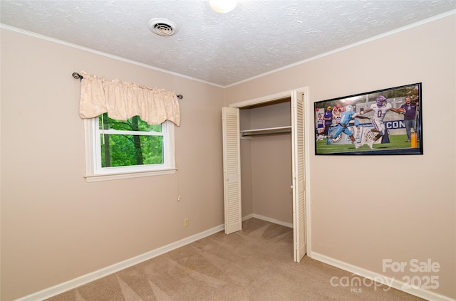 unfurnished bedroom with carpet floors, a closet, visible vents, a textured ceiling, and baseboards