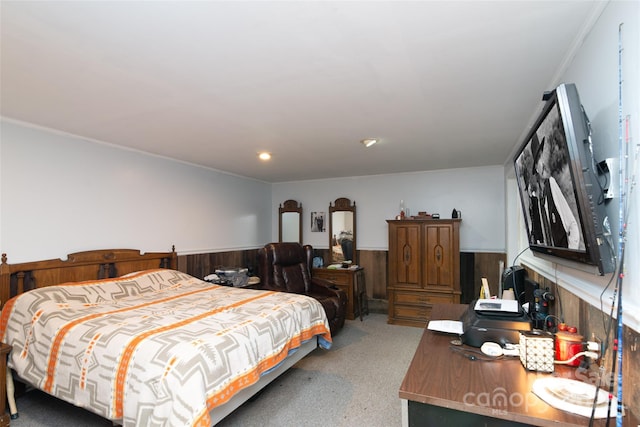 bedroom featuring wainscoting and wood walls