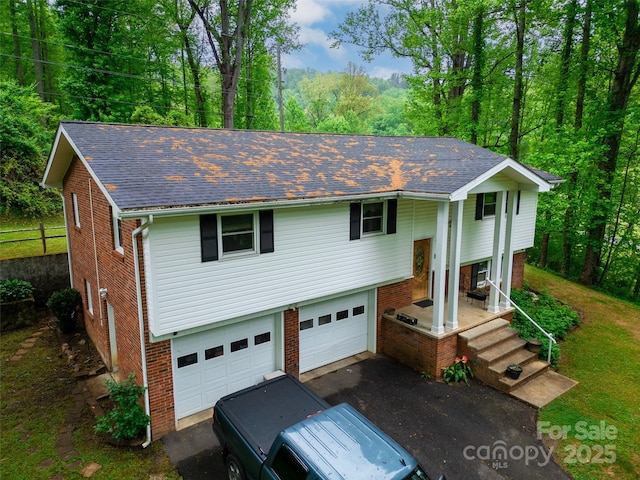 view of front of home featuring a garage, a shingled roof, and brick siding