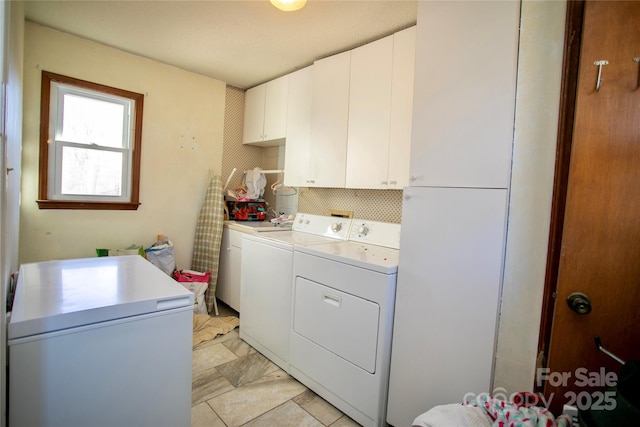 washroom featuring cabinets and washer and dryer