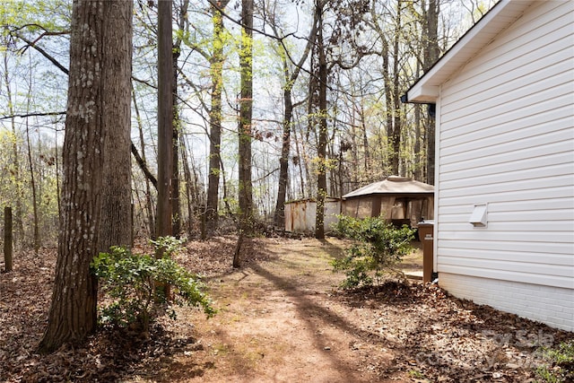 1035 Timberlane Dr, Lincolnton, NC 28092 - view of yard featuring a view of trees, an outdoor structure, and a storage shed