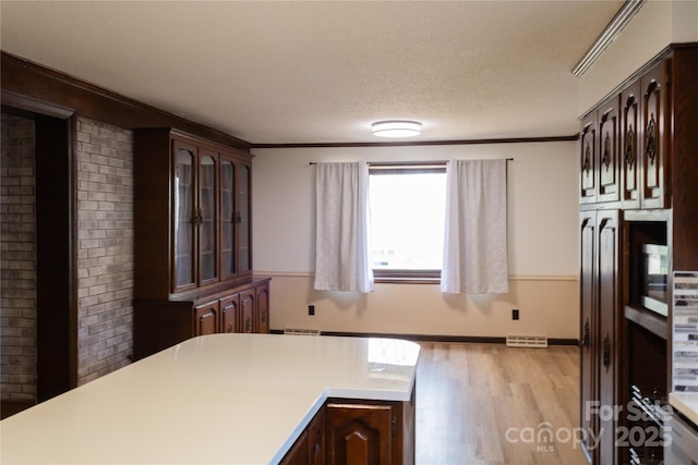 1035 Timberlane Dr, Lincolnton, NC 28092 - kitchen featuring light countertops, crown molding, light wood finished floors, and a textured ceiling